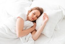 sleeping young woman lies bed with eyes closed